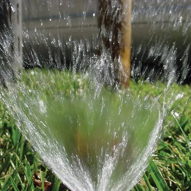 fresh water spraying cool moisture over grassy area